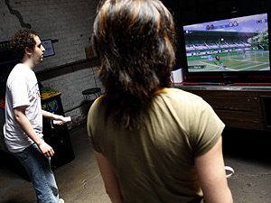 Barcade patrons play tennis on the Nintendo Wii