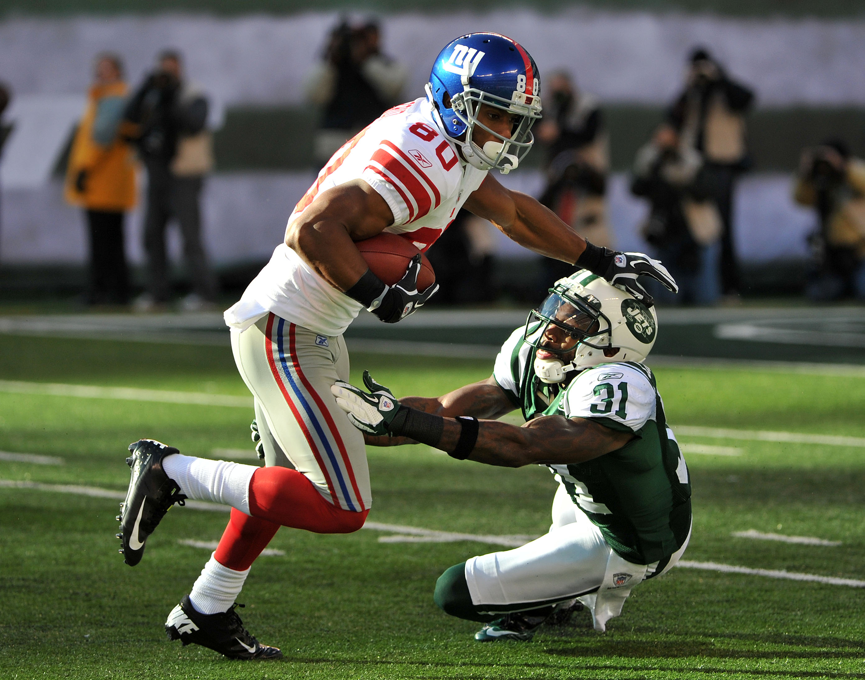 Victory Cruz, left, avoids a tackle by the Jets' Antonio Cromartie on Dec. 24, 2011. (Photo by Christopher Pasatieri/Getty Images) 