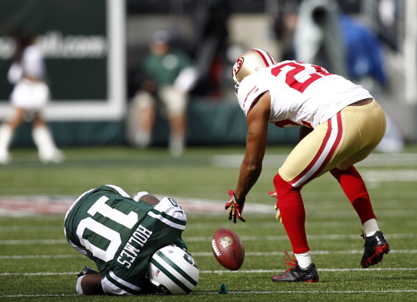Santonio Holmes, left, of the New York Jets writhes on the turf after fumbling a ball picked up by  Carlos Rogers of the San Francisco 49ers during a game at MetLife Stadium on September 30, 2012 in East Rutherford, New Jersey.  (credit: Jeff Zelevansky/Getty Images)
