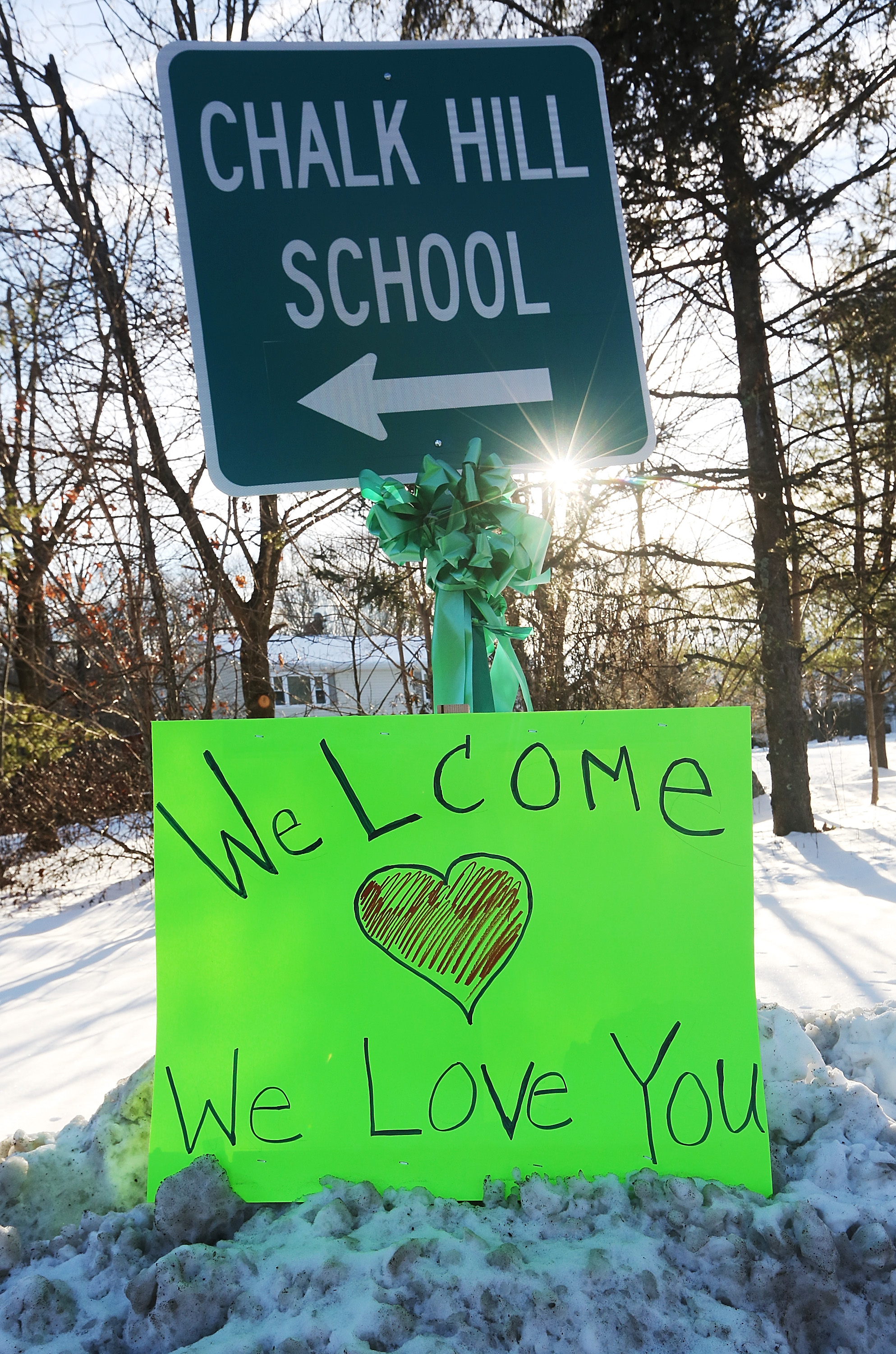 A sign reads 'Welcome We Love You' beneath a sign pointing to the location of Chalk Hill School, which has been refurbished and renamed Sandy Hook Elementary School on January 3, 2013 in Monroe, Connecticut. (Photo by Mario Tama/Getty Images) 