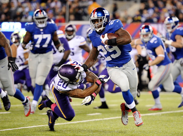 EAST RUTHERFORD, NJ - OCTOBER 21:  Running back Michael Cox #29 of the New York Giants avoids a tackle by cornerback Chris Cook #20 of the Minnesota Vikings during a game at MetLife Stadium on October 21, 2013 in East Rutherford, New Jersey.  (Photo by Maddie Meyer/Getty Images)