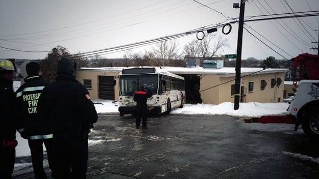 A NJ TRANSIT bus is towed out after it crashed into a building in Paterson, NJ on Friday, Jan. 3, 2014. (credit: Janelle Burrell/CBS 2)
