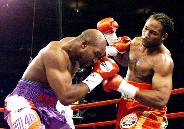 IBF and WBA Heavyweight Champion Evander Holyfield (L) ducks out of the way of a punch by WBC heavyweight Champion Lennox Lewis.
