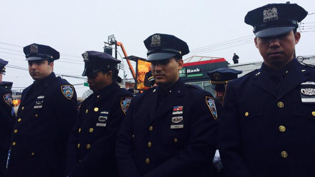Some police officers turn their backs outside Wenjian Liu's funeral on Jan. 4, 2015, as Mayor Bill de Blasio's euology is shown on a large video screen. (credit: Christine Sloan/CBS2)