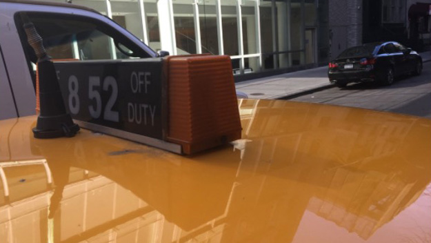 A man believes he was the victim of a credit card skimmer in this allegedly fake cab. He notes the medallion light had only three numbers. (Credit: CBS2)