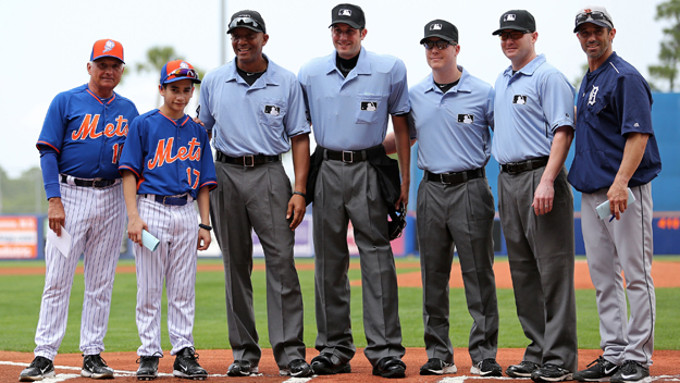Jayden Ramos, second from right,, the 13-year-old son of late NYPD officer Rafael Ramos, who was one of two policemen shot in the line of duty in Brooklyn this December, pose for a picture with Mets manager Terry Collins, Tigers manager Brad Ausmus and the umpires before the game at Tradition Field on March 6, 2015 in Port St. Lucie, Florida. (Photo by Rob Foldy/Getty Images)
