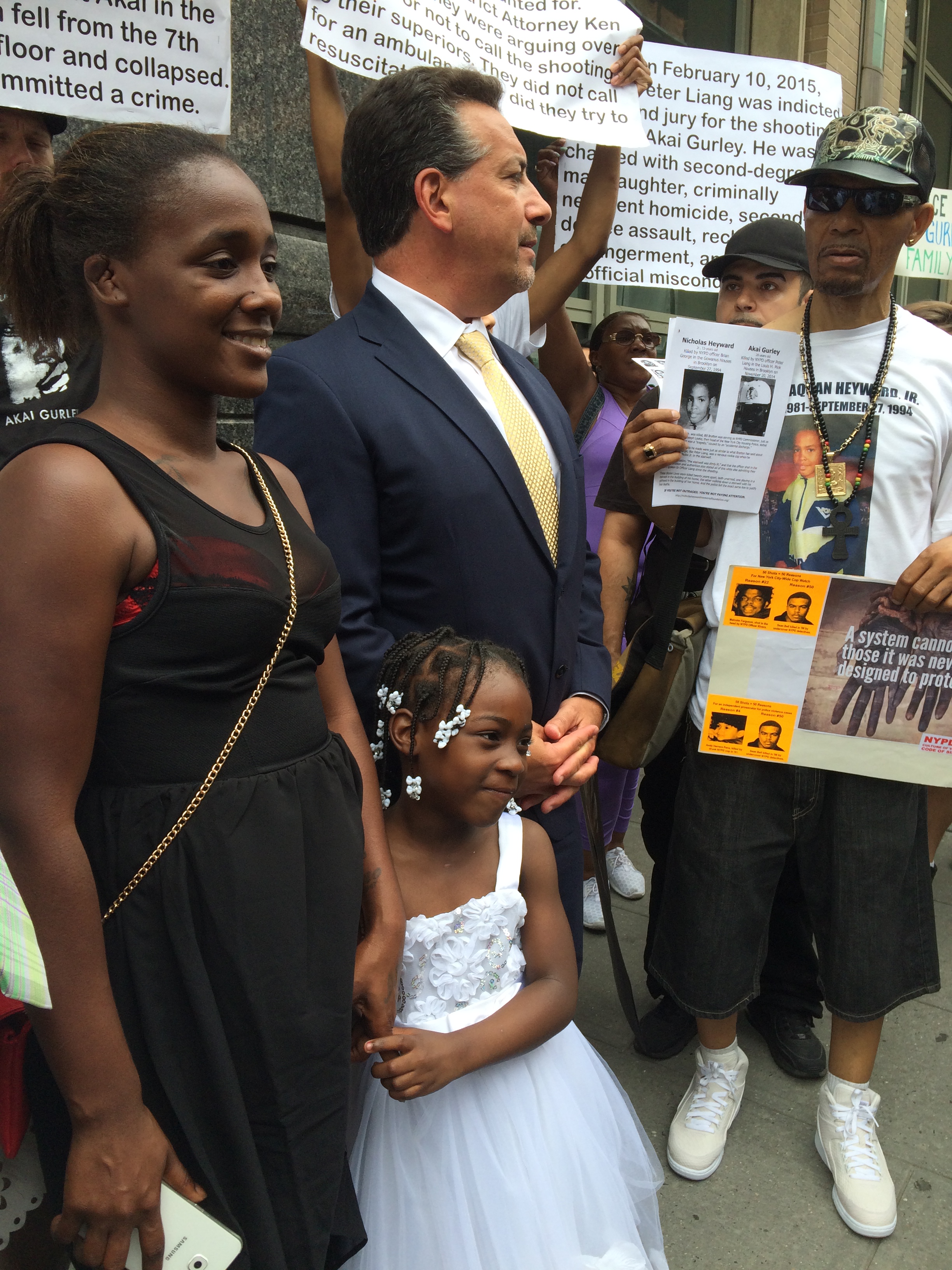 Akai Gurley's girlfriend, Kimberly Ballinger, and daughter stand with protesters outside  a hearing for accused NYPD officer Peter Liang (credit: Sonia Rincon/1010 WINS)