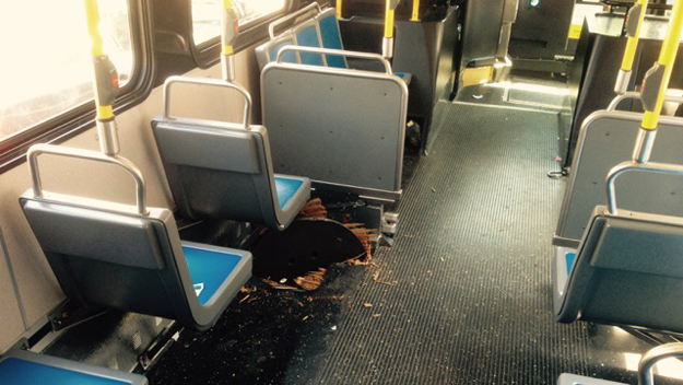 This manhole cover tore through the bottom of an MTA bus in the Bronx on Aug. 4, 2015. (credit: Image via CBS2) 