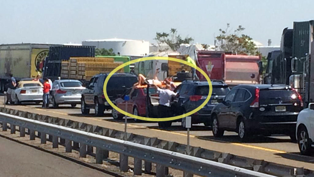 Delays on the NJ Turnpike were so bad following the truck fire one driver took to sunbathing on top of his car. (credit: Twitter/@GothamCarGuy)