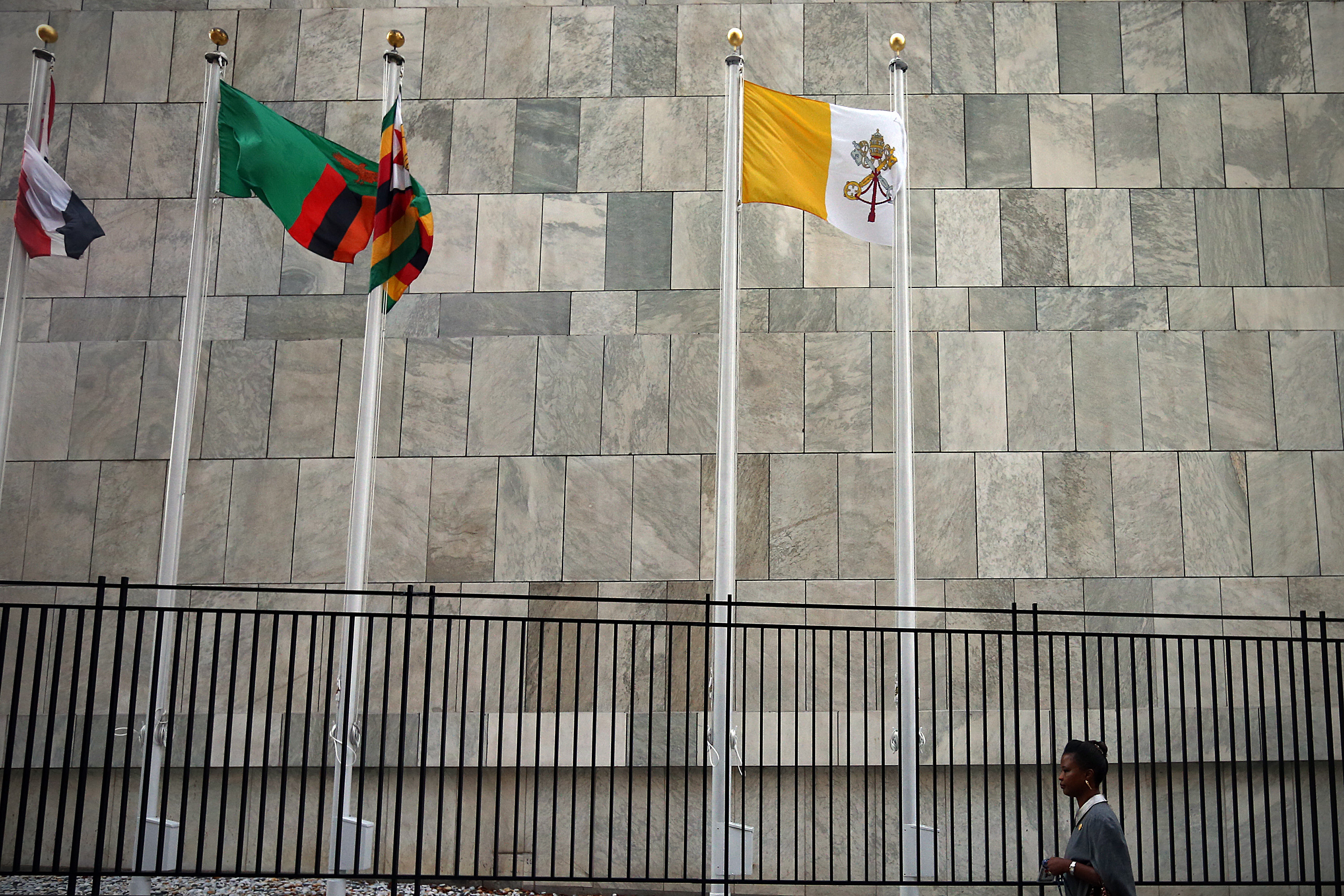 A woman walks past the Vatican flag as it is flown outside the United Nations headquarters on September 25, 2015. (Photo by Carl Court/Getty Images)
