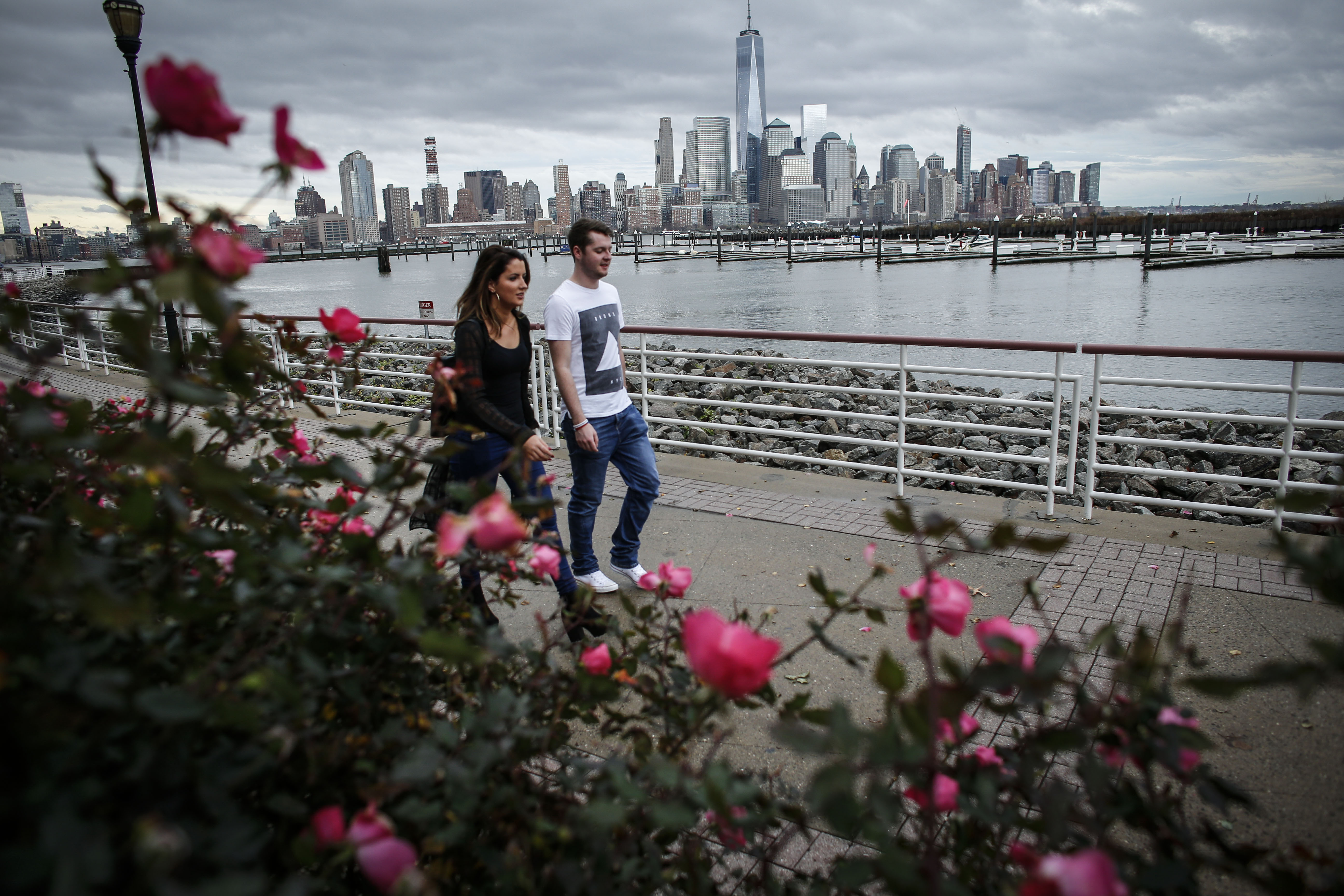 NEWPORT, NJ - DECEMBER 24: A couple walks by the Hudson River shore on December 24, 2015 in Newport, New Jersey. New York and New Jersey have seen highs in the upper 50s this week, with temperatures expected to reach the low 70s on Christmas Eve. (Photo by Kena Betancur/Getty Images)