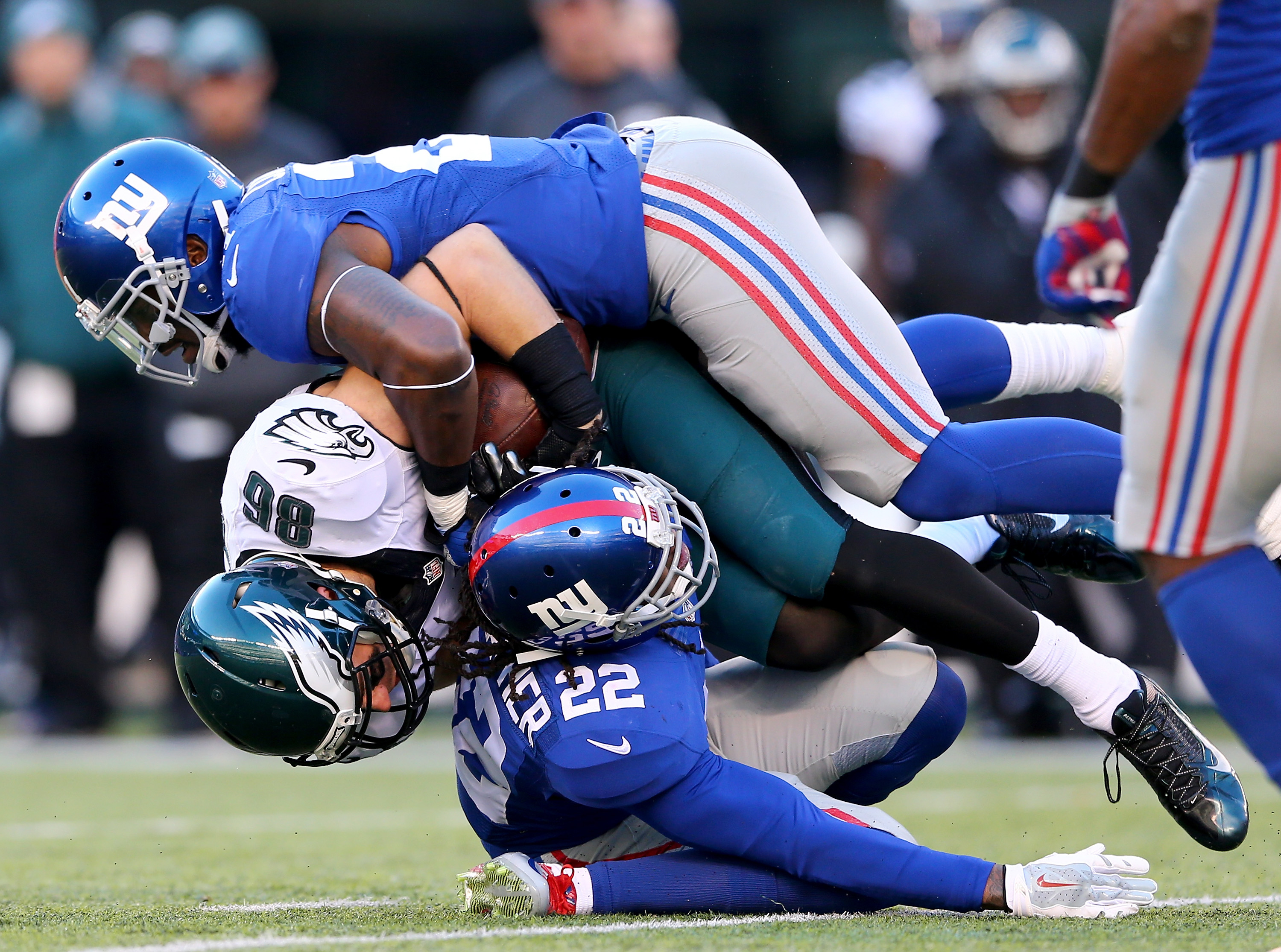 Landon Collins and Brandon Meriweather, bottom of the New York Giants tackle Zach Ertz of the Philadelphia Eagles at MetLife Stadium on Jan. 3, 2016. (Photo by Elsa/Getty Images)