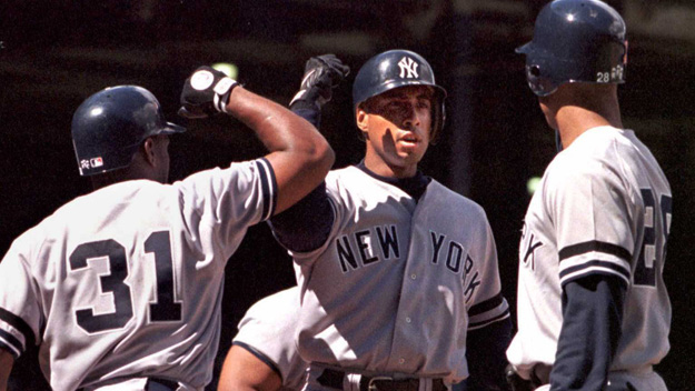 Yankees outfielder Bernie Williams is congratulated at home plate by Tim Raines and Ruben Rivera after Williams hit a three-run homer against the Detroit Tigers on Sept. 12, 1996, in Detroit. (Photo by Matt Campbell/AFP/Getty Images)